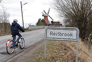 0592 Stadtteilschild Reitbrook - Fahrrad auf der Strasse - Mhle von Hambug Reitbrook im Hintergrund.